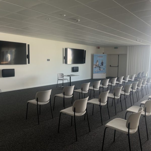 De conferentieruimte met stoelen bij Gymna Diepenbeek.